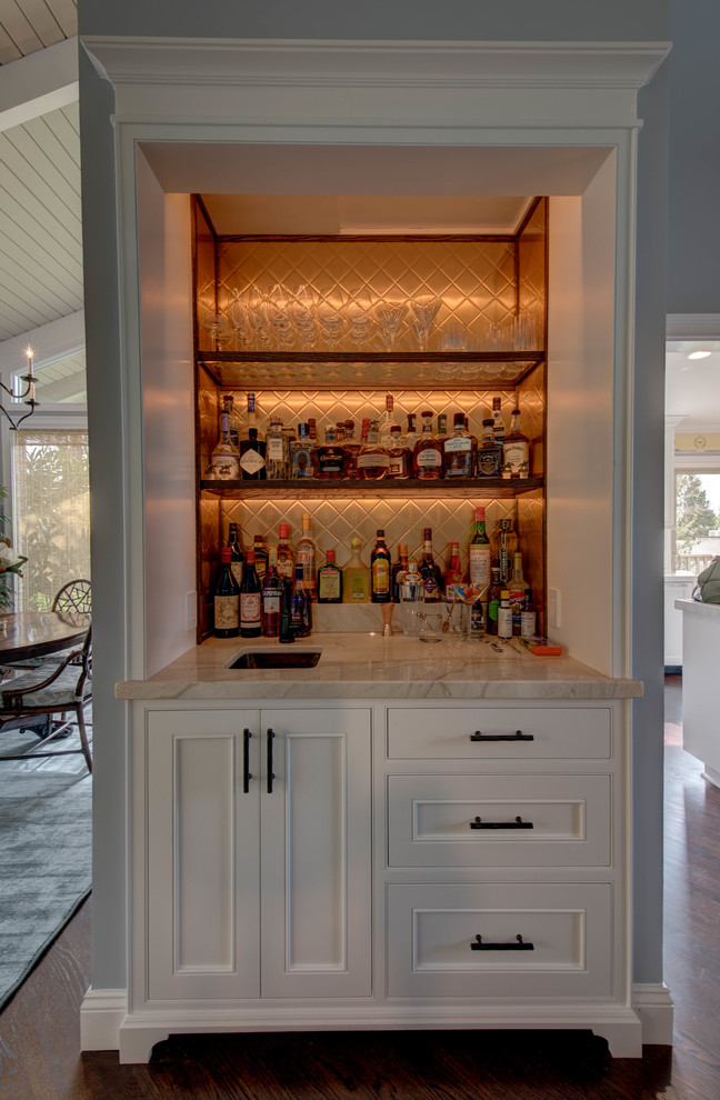 Photo of a mid-sized beach style single-wall wet bar in San Francisco with an undermount sink, recessed-panel cabinets, white cabinets, quartzite benchtops, brown splashback, glass tile splashback and dark hardwood floors.