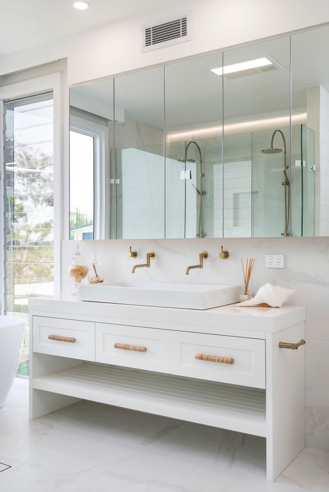 Photo of a contemporary bathroom in Newcastle - Maitland with white cabinets, a freestanding tub, white tile, a trough sink, white floor, white benchtops, a double vanity and shaker cabinets.