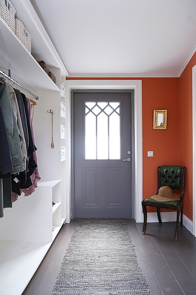 This is an example of a mid-sized traditional entryway in Stockholm with red walls and painted wood floors.
