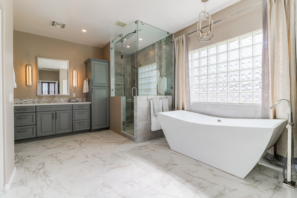 Freestanding bathtub - mid-sized transitional master beige tile and porcelain tile porcelain tile, white floor and double-sink freestanding bathtub idea in Phoenix with raised-panel cabinets, gray cabinets, a two-piece toilet, beige walls, an undermount sink, quartz countertops, a hinged shower door, white countertops and a built-in vanity
