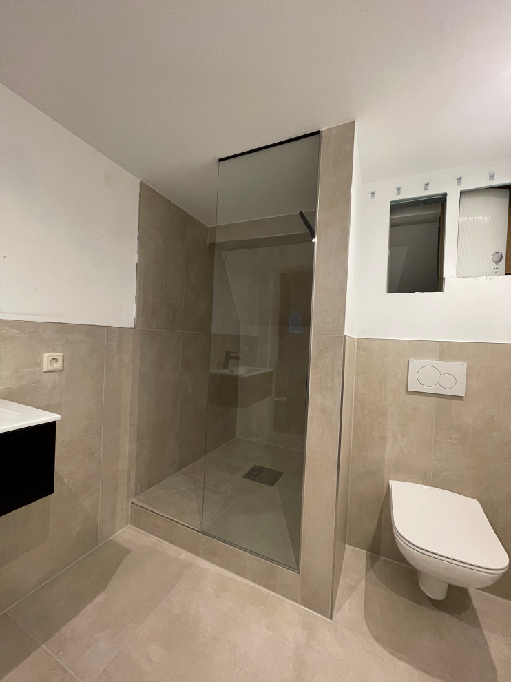 Mittelgroßes Modernes Duschbad mit flächenbündigen Schrankfronten, schwarzen Schränken, Duschnische, Wandtoilette, grauen Fliesen, Keramikfliesen, weißer Wandfarbe, Betonboden, Wandwaschbecken, Mineralwerkstoff-Waschtisch, grauem Boden, Schiebetür-Duschabtrennung, Einzelwaschbecken und schwebendem Waschtisch in Sonstige