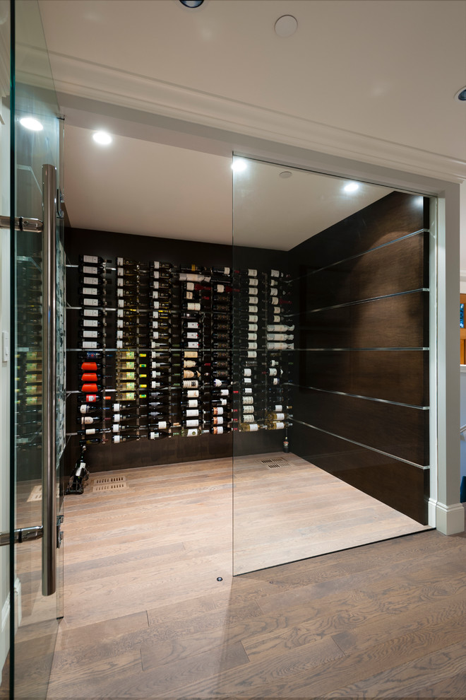 This is an example of a mid-sized transitional wine cellar in Vancouver with medium hardwood floors and storage racks.