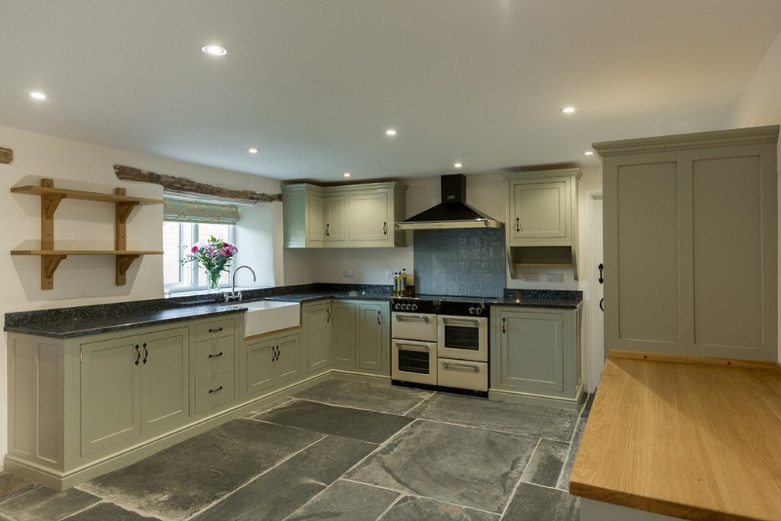 Design ideas for a large country u-shaped separate kitchen in Cornwall with a farmhouse sink, shaker cabinets, grey cabinets, granite benchtops, blue splashback, ceramic splashback, panelled appliances, slate floors, no island, grey floor and grey benchtop.