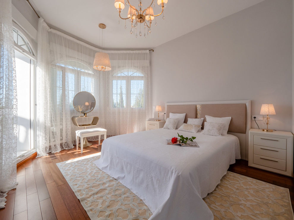 Diseño de dormitorio principal tradicional renovado grande con paredes beige y suelo de madera en tonos medios