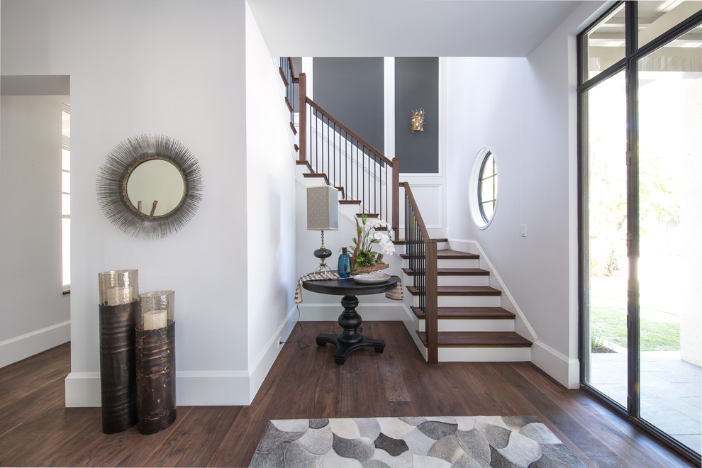 Photo of a mid-sized transitional foyer in Charleston with white walls, medium hardwood floors, a single front door, a glass front door and brown floor.