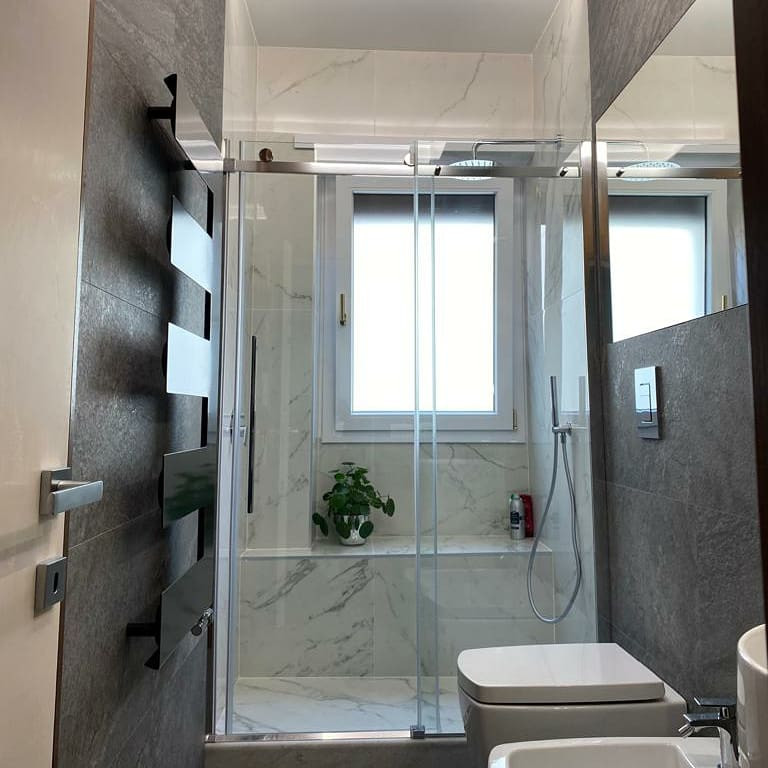 Design ideas for a mid-sized contemporary bathroom in Rome with open cabinets, white cabinets, a wall-mount toilet, gray tile, stone slab, grey walls, marble floors, a pedestal sink, solid surface benchtops, grey floor, white benchtops and a freestanding vanity.