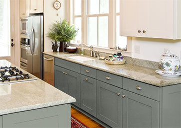 Example of a transitional single-wall light wood floor open concept kitchen design in Grand Rapids with an integrated sink, recessed-panel cabinets, blue cabinets, marble countertops, stainless steel appliances and an island