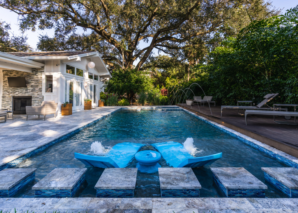 Cette photo montre un piscine avec aménagement paysager arrière rétro de taille moyenne et rectangle avec des pavés en béton.