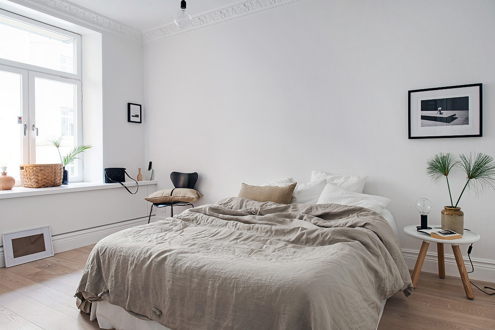 Mid-sized scandinavian master bedroom in Gothenburg with white walls, light hardwood floors and no fireplace.