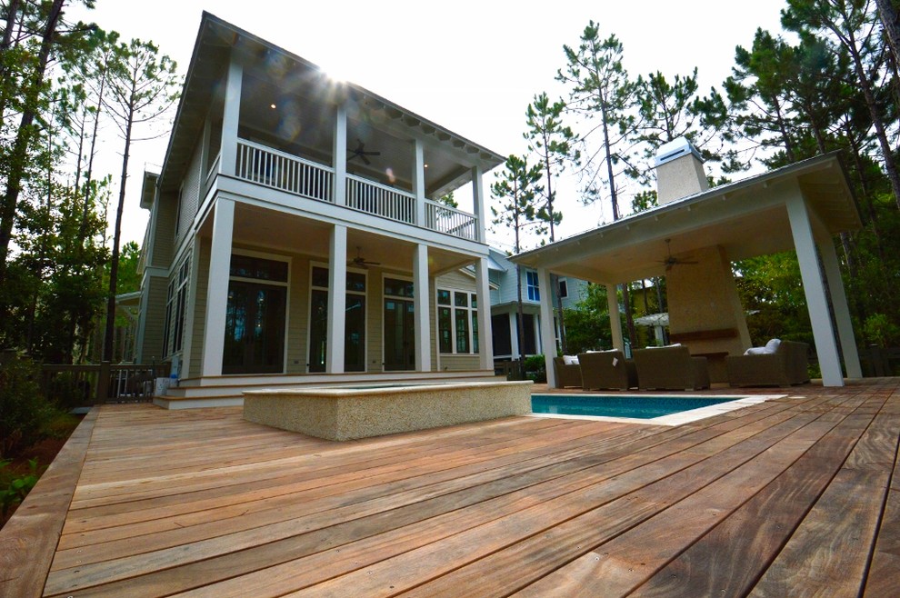 Inspiration for a large beach style backyard deck in Miami with a roof extension.