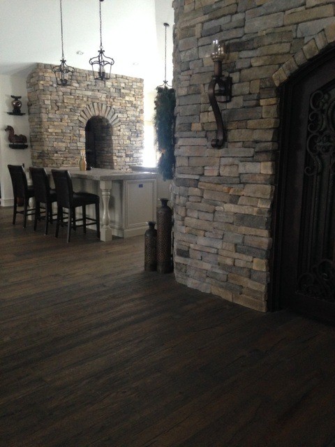 Mid-sized transitional galley dark wood floor and brown floor enclosed kitchen photo in Calgary with an undermount sink, recessed-panel cabinets, white cabinets, limestone countertops, gray backsplash, brick backsplash, stainless steel appliances and a peninsula