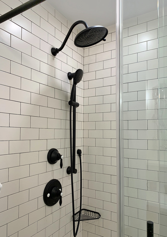 Photo of a large eclectic master bathroom in Philadelphia with recessed-panel cabinets, black cabinets, an alcove shower, a one-piece toilet, white tile, subway tile, white walls, porcelain floors, an undermount sink, engineered quartz benchtops, black floor, a sliding shower screen and white benchtops.