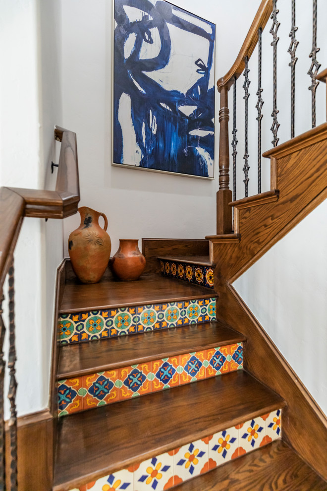 Ejemplo de escalera en L de estilo americano de tamaño medio con escalones de madera, contrahuellas con baldosas y/o azulejos y barandilla de metal
