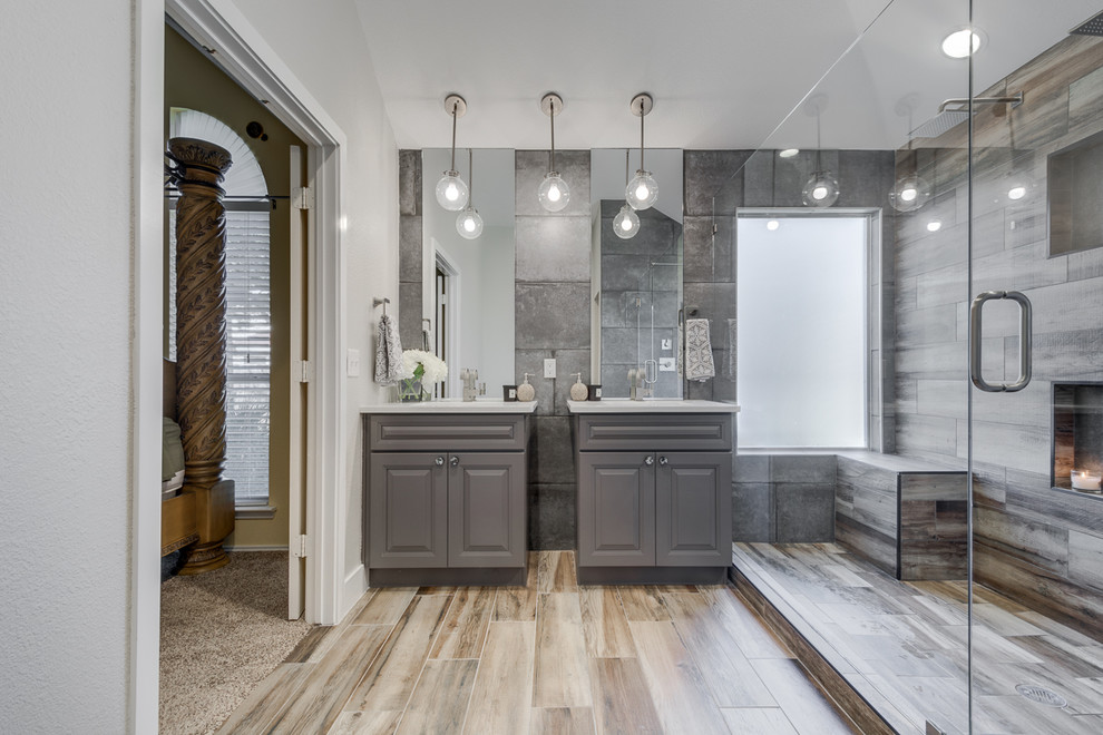 This is an example of a mid-sized transitional master bathroom in Dallas with shaker cabinets, grey cabinets, a one-piece toilet, gray tile, porcelain tile, grey walls, porcelain floors, solid surface benchtops and a console sink.