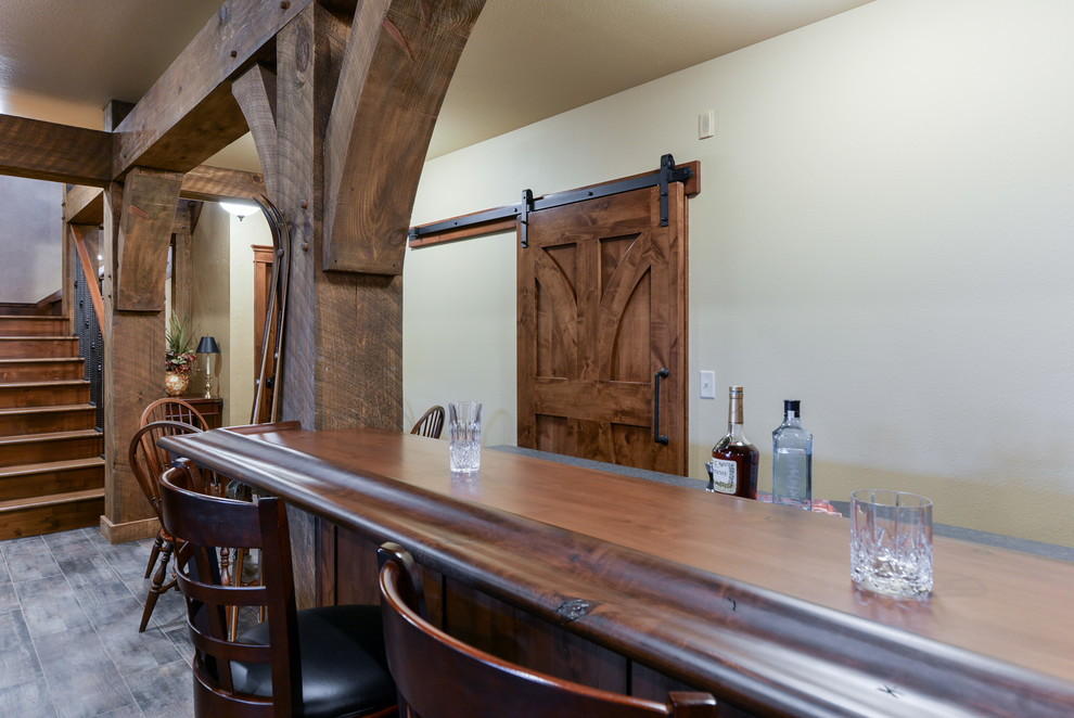Example of a mountain style galley home bar design with shaker cabinets, medium tone wood cabinets and wood countertops