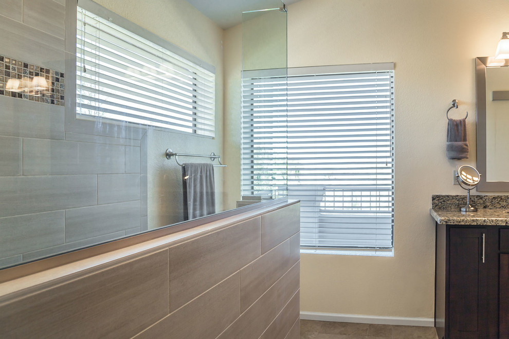 Walk-in shower - large transitional master brown tile and porcelain tile ceramic tile walk-in shower idea in Phoenix with recessed-panel cabinets, dark wood cabinets, a two-piece toilet, beige walls, an undermount sink and granite countertops