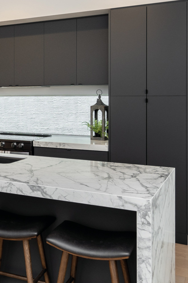 Esempio di una cucina moderna di medie dimensioni con lavello da incasso, ante lisce, ante nere, top in superficie solida, paraspruzzi bianco, paraspruzzi in gres porcellanato, pavimento in compensato, pavimento beige e top bianco