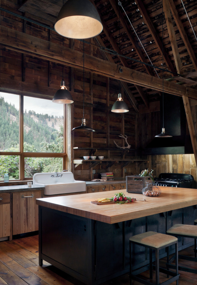 This is an example of a country kitchen in Seattle with a farmhouse sink and black appliances.