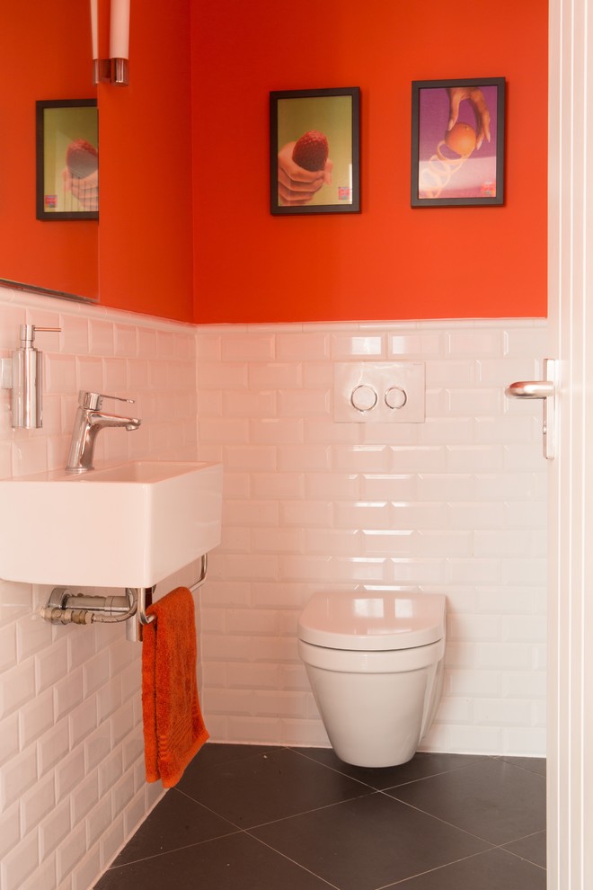 Design ideas for a small retro ensuite bathroom in Kent with a wall mounted toilet, white tiles, orange walls and a wall-mounted sink.