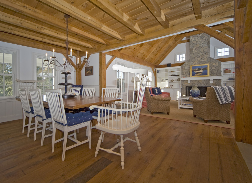 Photo of a country open plan dining in Boston with white walls, medium hardwood floors and a stone fireplace surround.