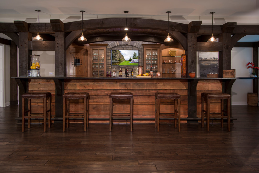 This is an example of a large country home bar in Detroit with dark hardwood floors.
