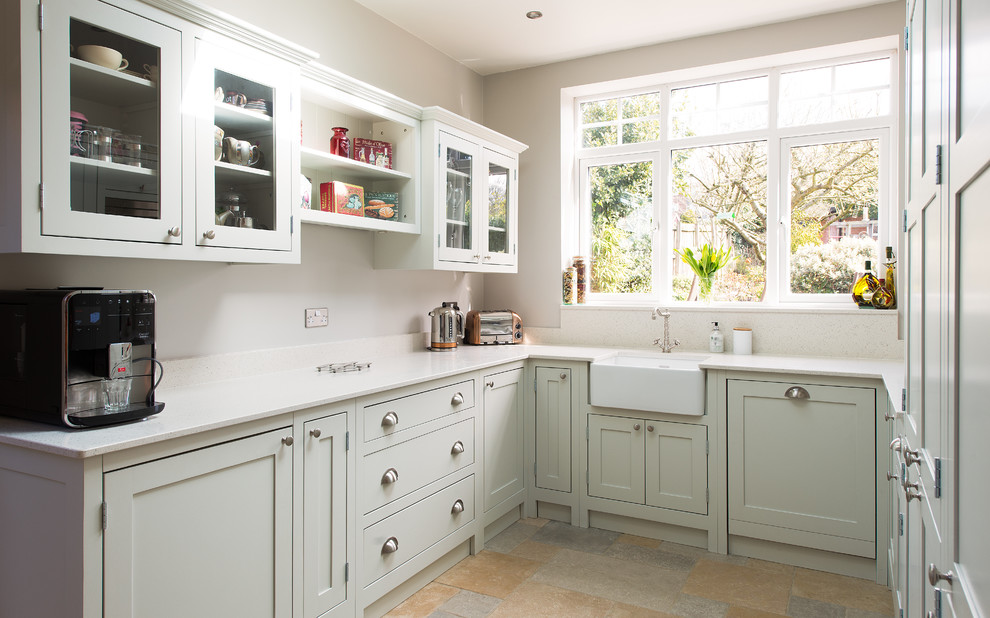 Design ideas for a mid-sized traditional u-shaped separate kitchen in Gloucestershire with light wood cabinets, quartzite benchtops, ceramic floors, a farmhouse sink, glass-front cabinets, porcelain splashback and no island.