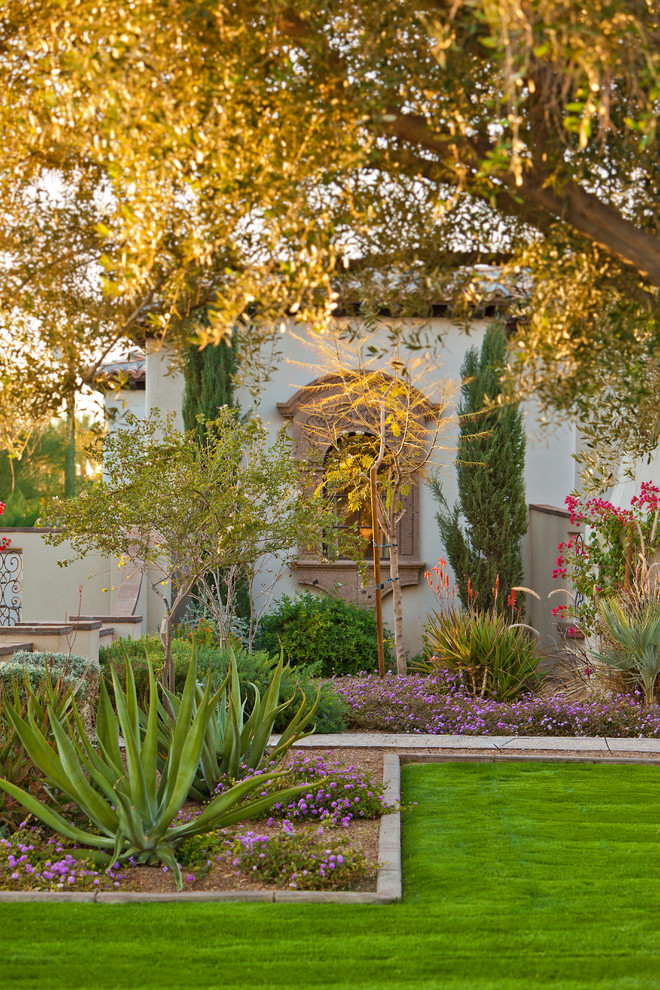 Inspiration for a large mediterranean front yard partial sun formal garden in Phoenix with a garden path and natural stone pavers.