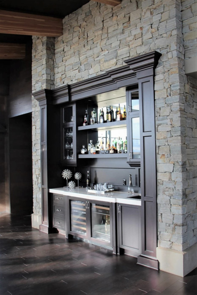 Foto di un grande angolo bar con lavandino tradizionale con lavello sottopiano, ante di vetro, ante in legno bruno, top in granito, paraspruzzi in legno, parquet scuro, pavimento marrone e top bianco