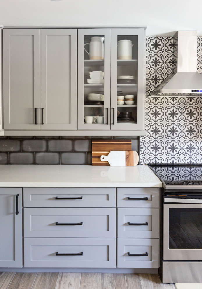 Eat-in kitchen - mid-sized transitional u-shaped light wood floor and gray floor eat-in kitchen idea in Phoenix with an undermount sink, recessed-panel cabinets, gray cabinets, quartz countertops, multicolored backsplash, ceramic backsplash, stainless steel appliances, an island and white countertops