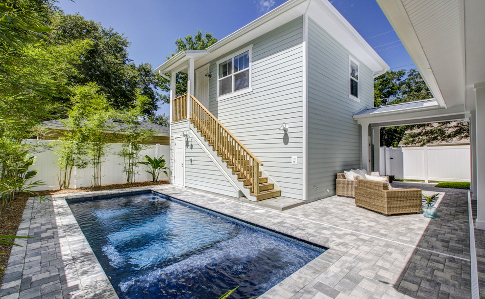 This is an example of a small beach style courtyard rectangular lap pool in Tampa with concrete pavers.