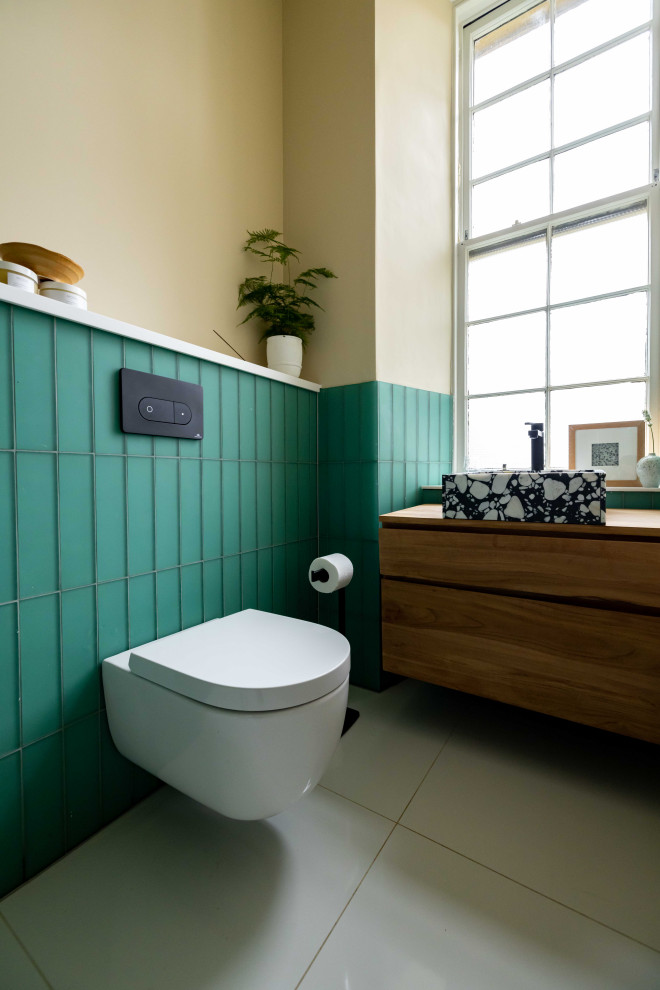 Пример оригинального дизайна: ванная комната среднего размера в современном стиле с душевой комнатой, инсталляцией, зеленой плиткой, стеклянной плиткой, полом из керамической плитки, душевой кабиной, подвесной раковиной, открытым душем, тумбой под одну раковину, подвесной тумбой и многоуровневым потолком
