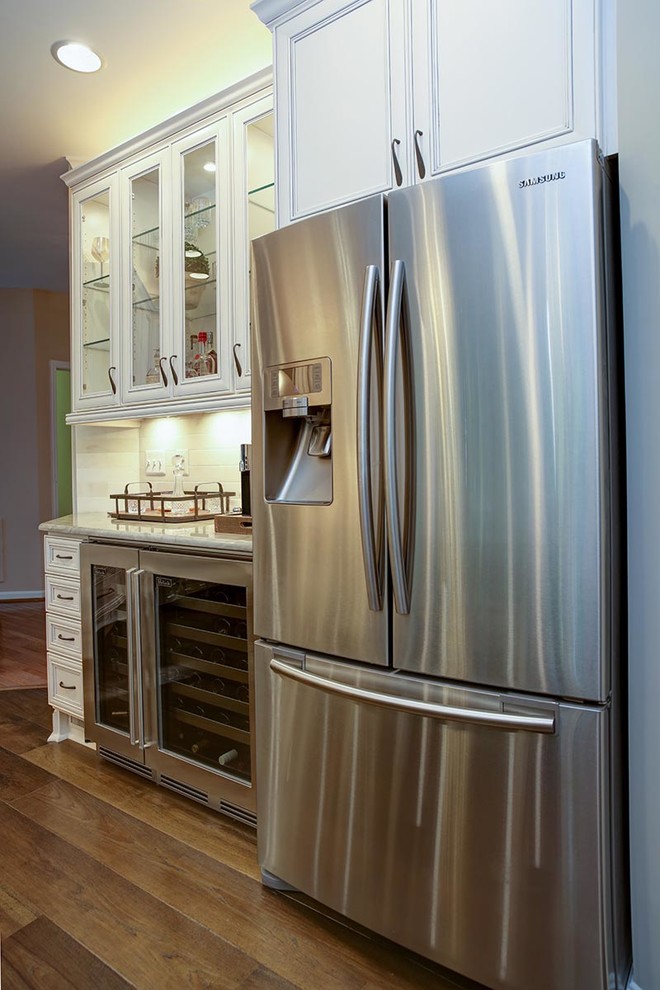 Inspiration for a transitional u-shaped dark wood floor eat-in kitchen remodel in Cedar Rapids with a farmhouse sink, flat-panel cabinets, white cabinets, marble countertops, stainless steel appliances and an island