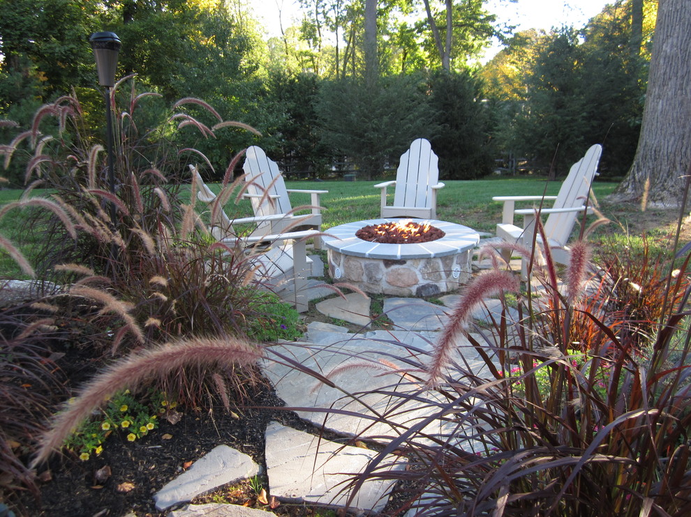 Mid-sized country backyard patio in Philadelphia with a fire feature, natural stone pavers and a pergola.