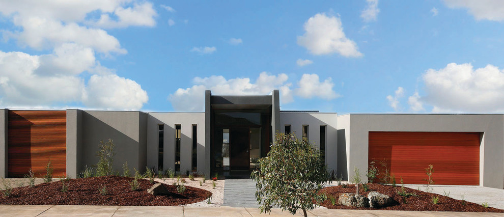 Mid-sized contemporary one-storey brick grey house exterior in Geelong with a flat roof and a metal roof.