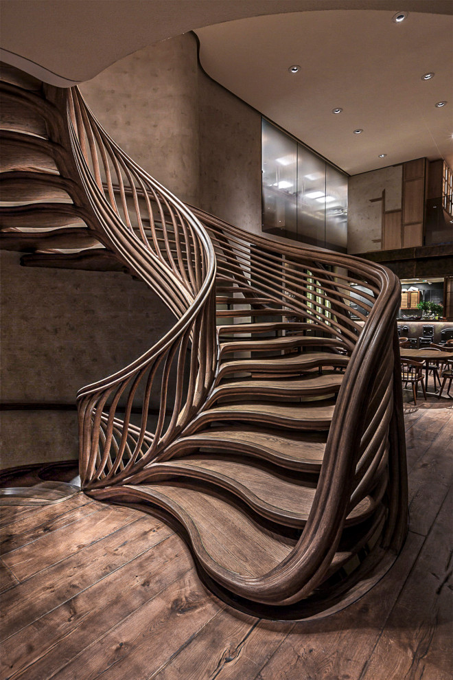 Large bohemian wood spiral wood railing staircase in London.