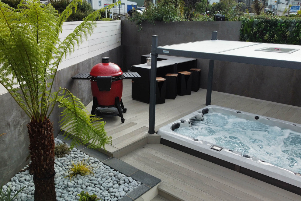 Small contemporary back patio in Cornwall with an outdoor kitchen, decking and no cover.