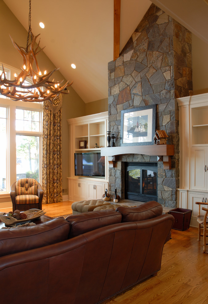 Inspiration for a large contemporary formal open concept living room in Boston with beige walls, medium hardwood floors, a standard fireplace, a stone fireplace surround and a freestanding tv.
