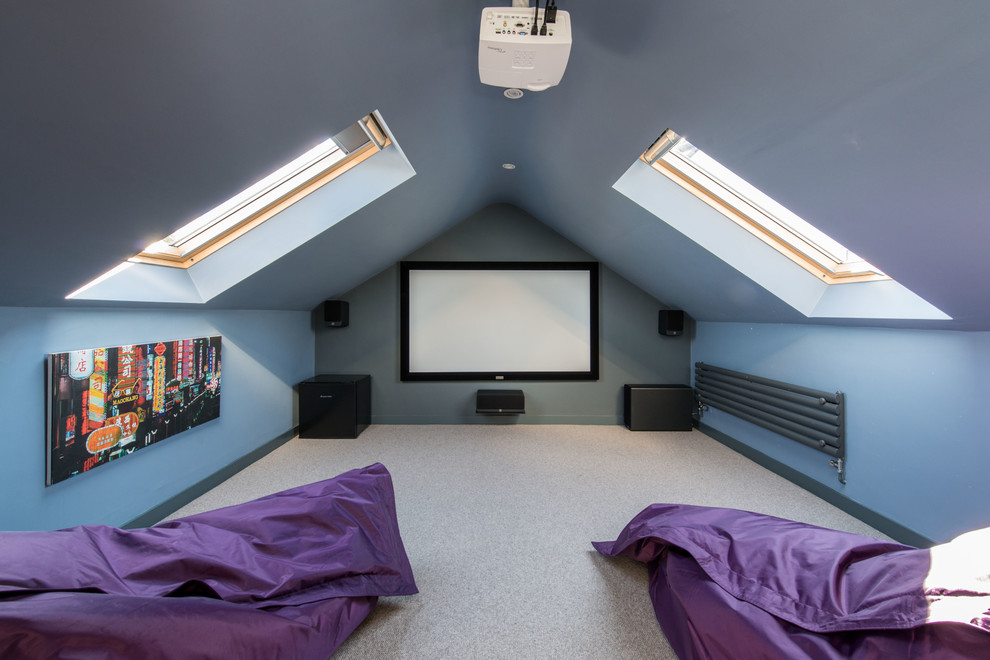 Photo of a mid-sized contemporary enclosed home theatre in Other with blue walls, carpet, a projector screen and grey floor.