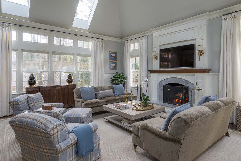 This is an example of a traditional enclosed family room in Boston with grey walls, carpet, a standard fireplace, a stone fireplace surround and a wall-mounted tv.