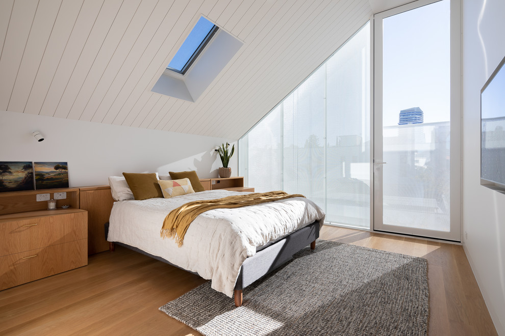 Small contemporary master bedroom in Melbourne with white walls, light hardwood floors and brown floor.