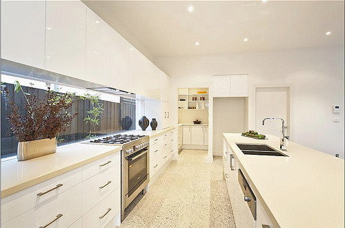 This is an example of a contemporary single-wall kitchen pantry in Melbourne with granite benchtops and concrete floors.
