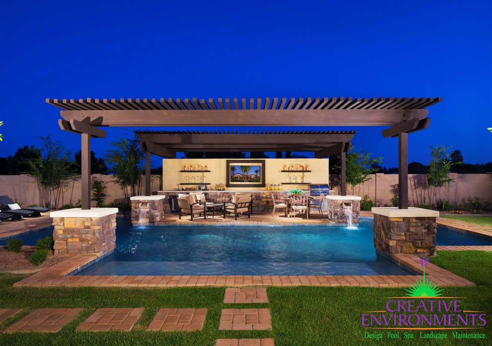 Expansive transitional backyard custom-shaped pool in Phoenix with a water feature and brick pavers.