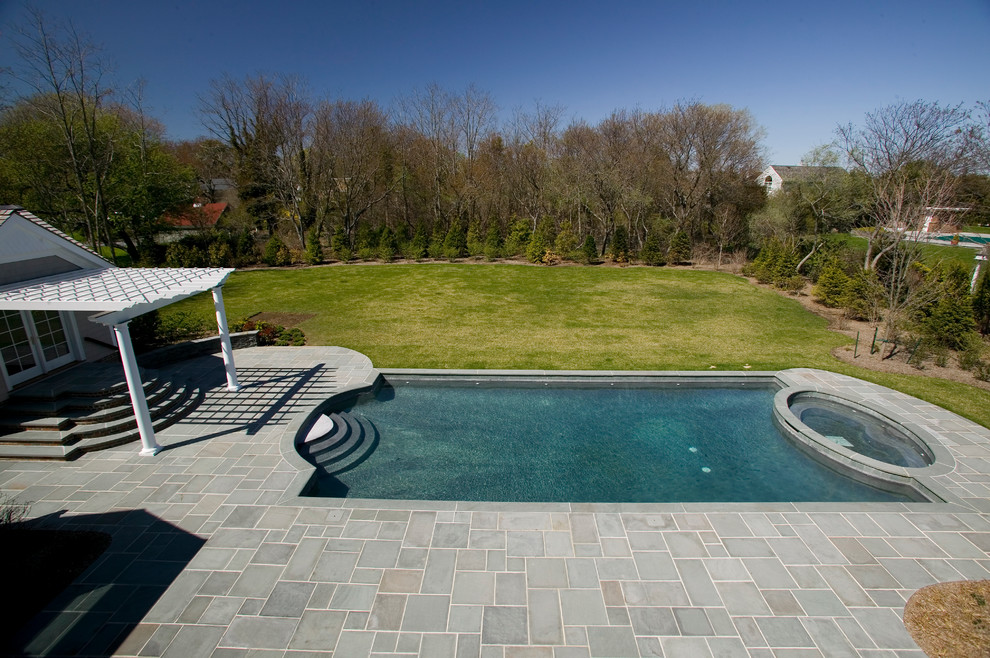 Inspiration for a mid-sized contemporary backyard rectangular pool in New York with a pool house and natural stone pavers.