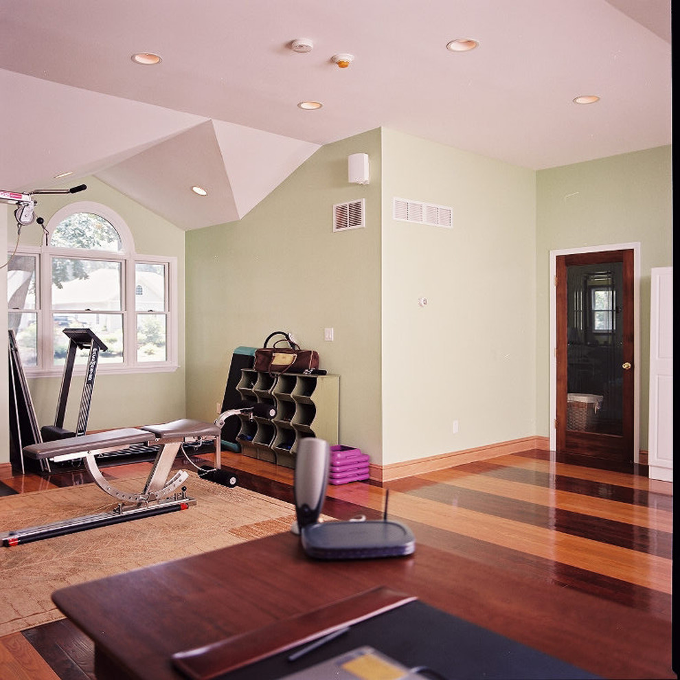 This is an example of a mid-sized traditional multipurpose gym in New York with green walls and dark hardwood floors.