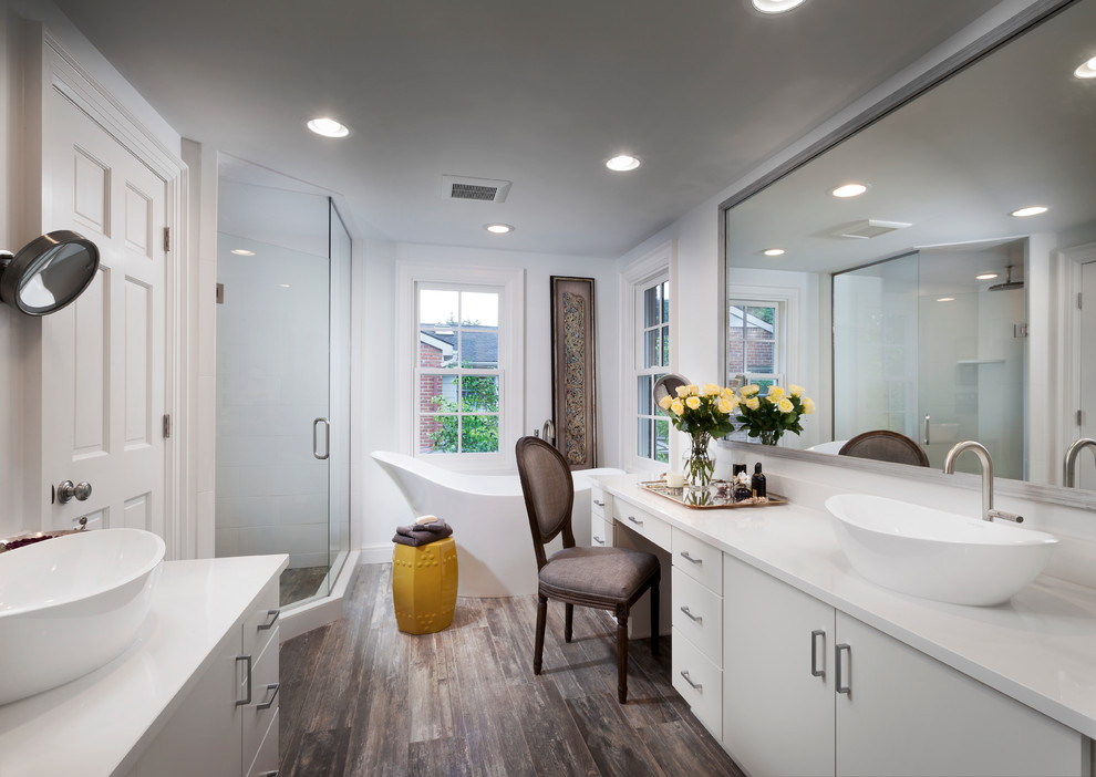 This is an example of a transitional bathroom in Detroit with flat-panel cabinets, white cabinets, a freestanding tub, a corner shower, white walls, dark hardwood floors and a vessel sink.
