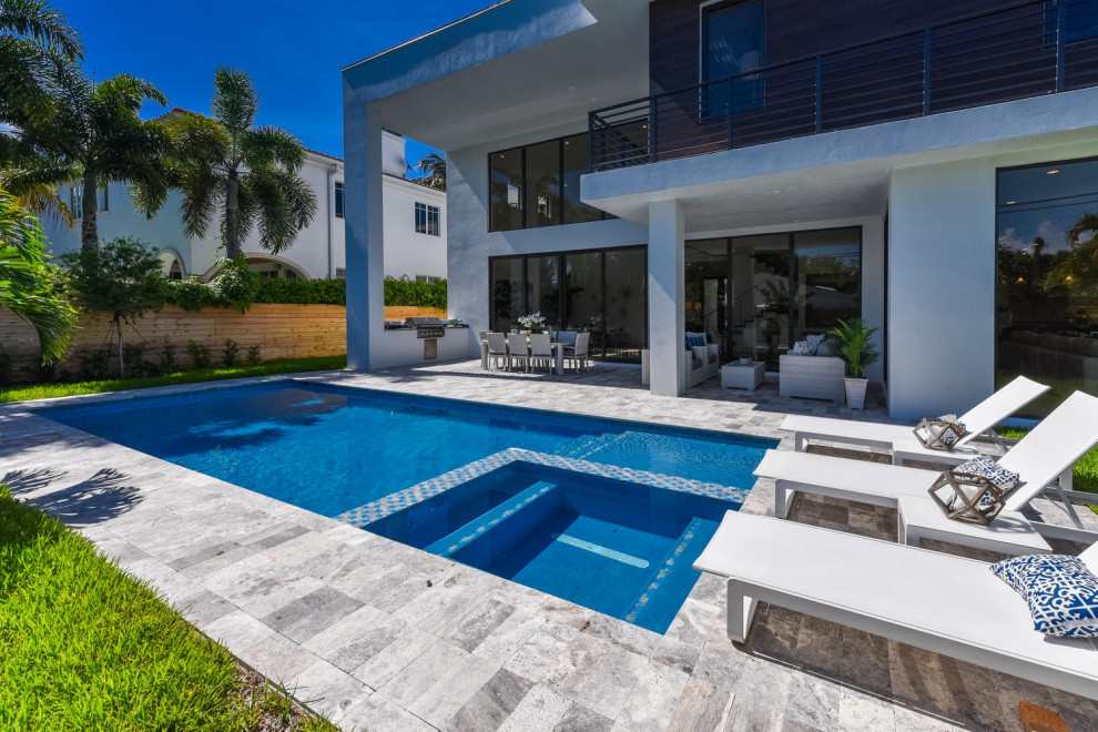 Design ideas for a modern backyard rectangular pool in Miami with a pool house and tile.