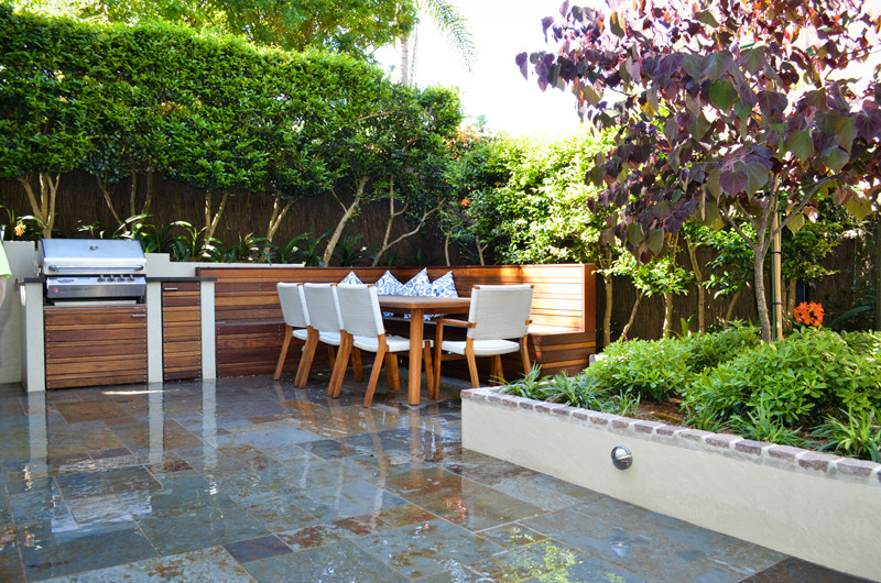 Design ideas for a contemporary backyard patio in Sydney with natural stone pavers.