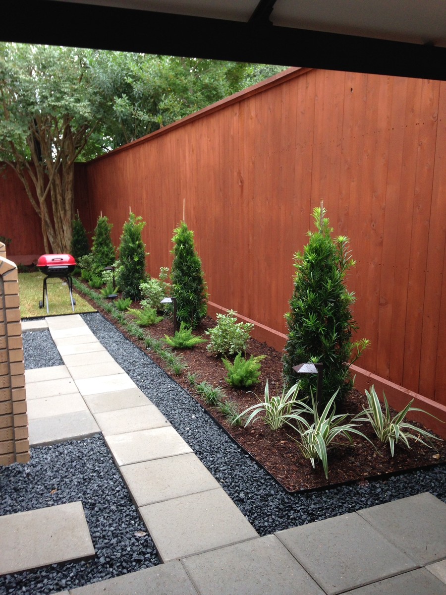 This is an example of a small modern backyard patio in Houston with concrete pavers and no cover.