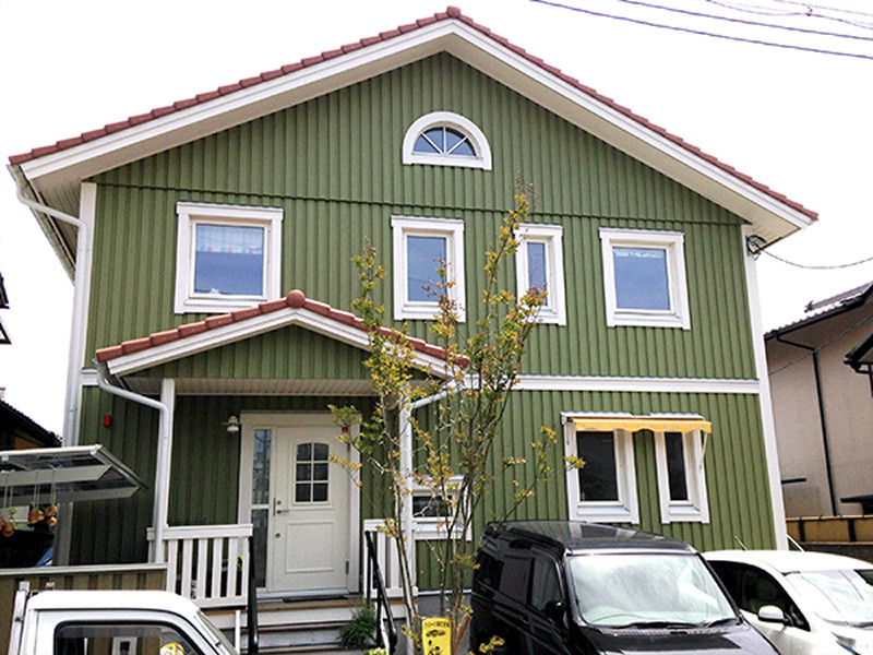 Design ideas for a mid-sized scandinavian two-storey green house exterior in Kobe with wood siding, a gable roof and a tile roof.