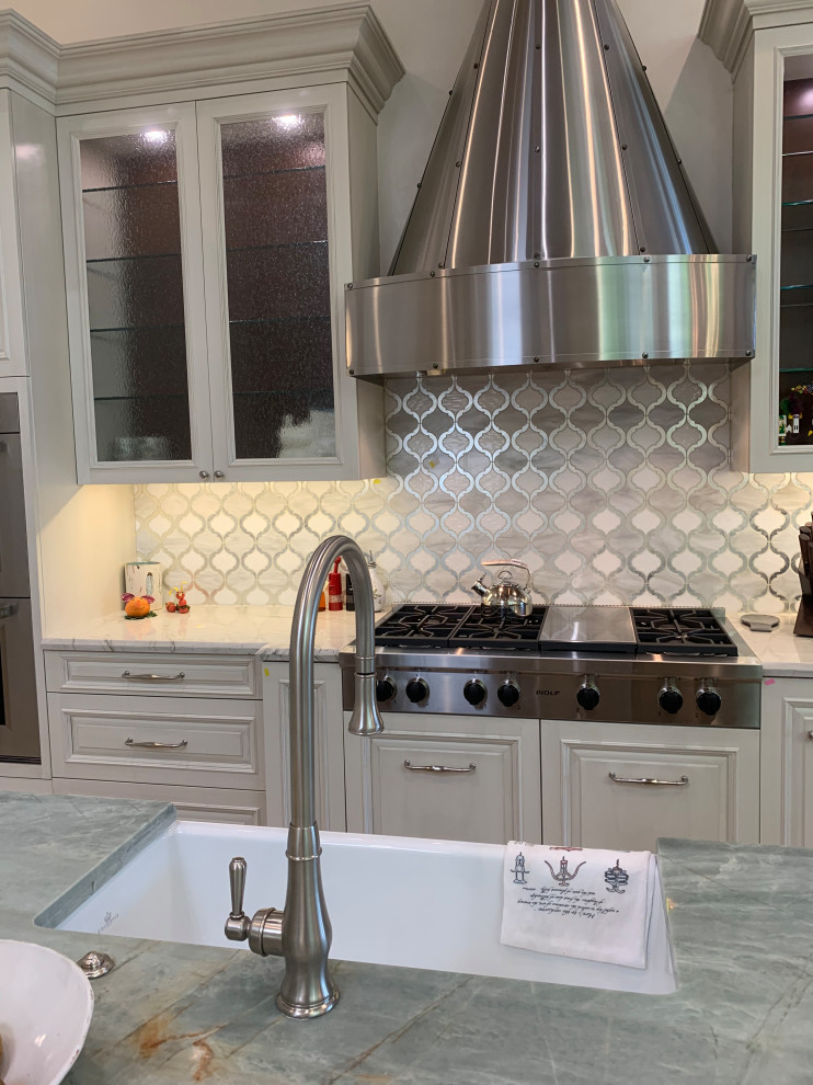 Inspiration for a large transitional u-shaped kitchen in Miami with a farmhouse sink, raised-panel cabinets, white cabinets, quartzite benchtops, white splashback, mosaic tile splashback, panelled appliances, marble floors, with island, beige floor, green benchtop and coffered.